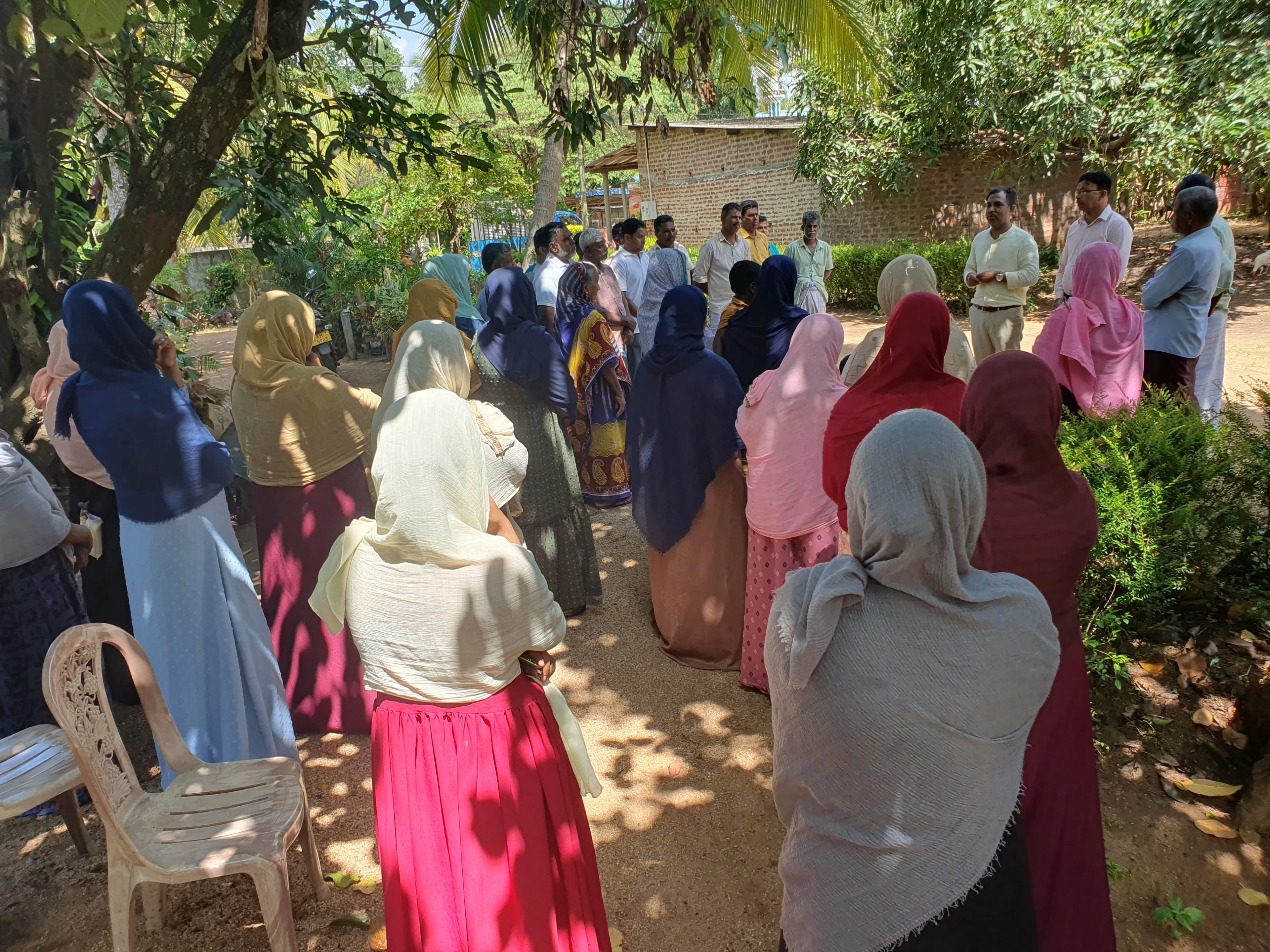 Community members gathered outdoors for a UDF meeting in a Sri Lankan village